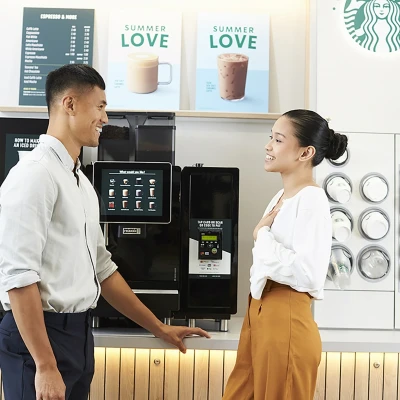 Starbucks koffiecorner waar 2 mensen gezellig staan te praten