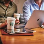 Mannen aan het werk met een laptop en SB koffie